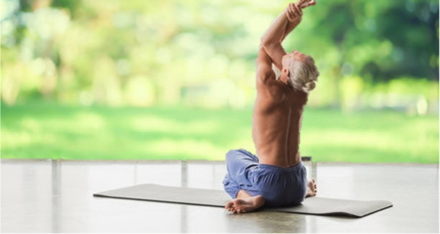 Homme senior effectuant un étirement sur un tapis de yoga dans un environnement naturel, symbolisant le soulagement des douleurs corporelles grâce aux bienfaits du Shiatsu au cabinet Terre de Shiatsu à Lyon 5e.