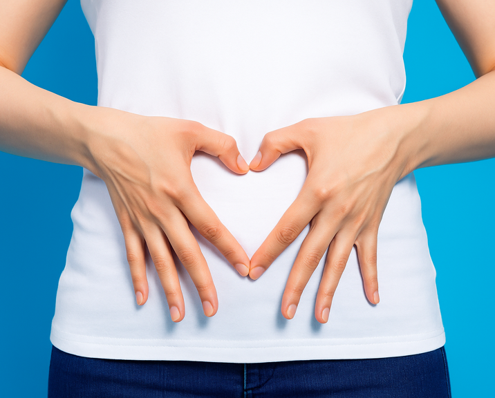 Femme faisant un coeur avec ses mains sur son ventre 